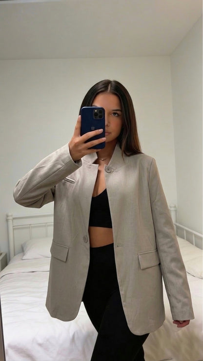 Blazer femme jaune porté ouvert sur pantalon noir
