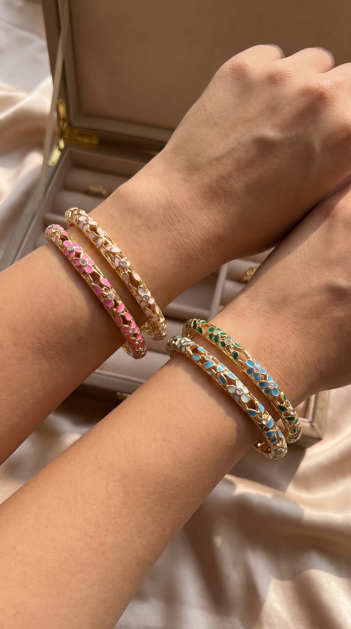 Bracelets jonc émaillés fleuris portés aux poignets, plusieurs coloris